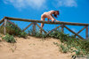 Nudist Woman Jumping the Fence on the Beach